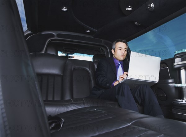 Hispanic businessman typing on laptop