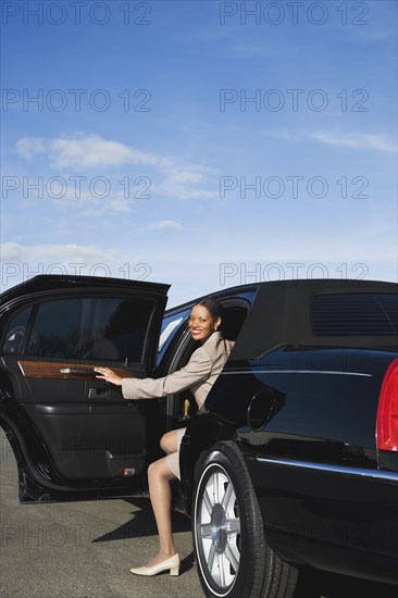 African businesswoman getting out of limousine