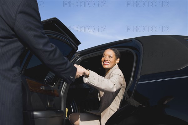 African businesswoman getting out of limousine