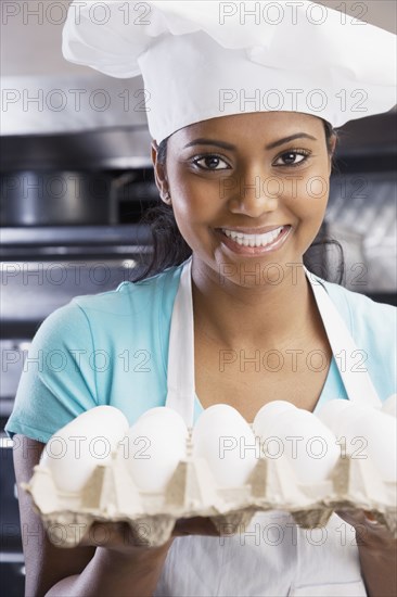 Mixed Race female chef holding eggs