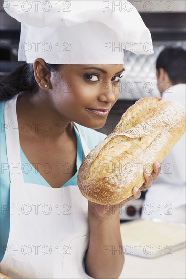 Mixed Race female baker smelling fresh bread