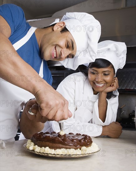 Hispanic male pastry chef decorating cake