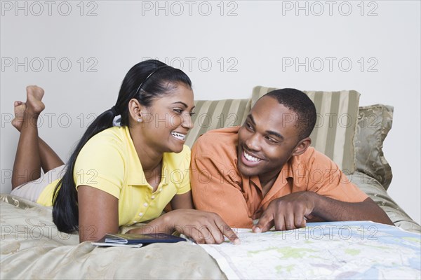 Multi-ethnic couple looking at map