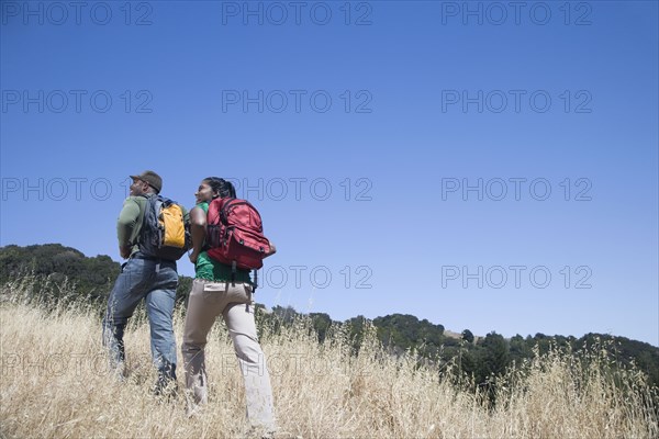 Multi-ethnic couple backpacking in rural area