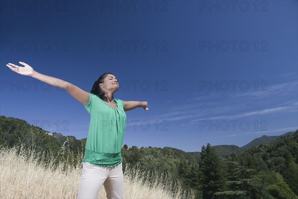 Mixed race woman outdoors with arms outstretched