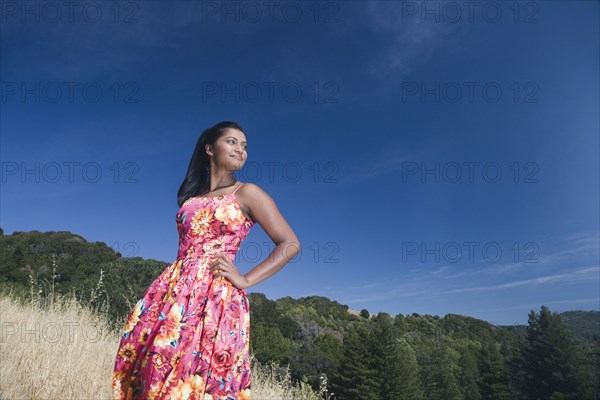 Mixed race woman in sundress in rural area