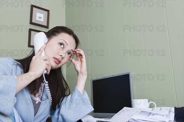 Stressed woman talking on telephone