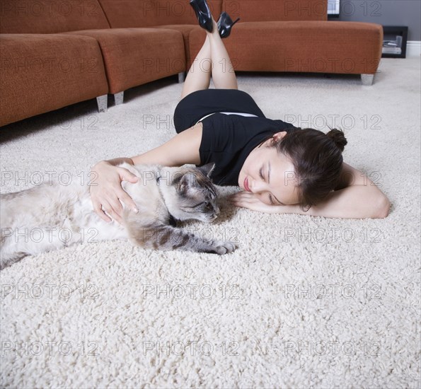 Woman petting cat on floor