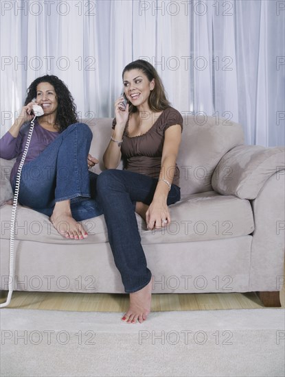 Mother and adult daughter using different phones