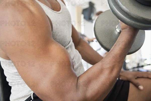 African man doing biceps curls with dumbbell