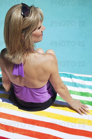 Caucasian woman sitting near swimming pool