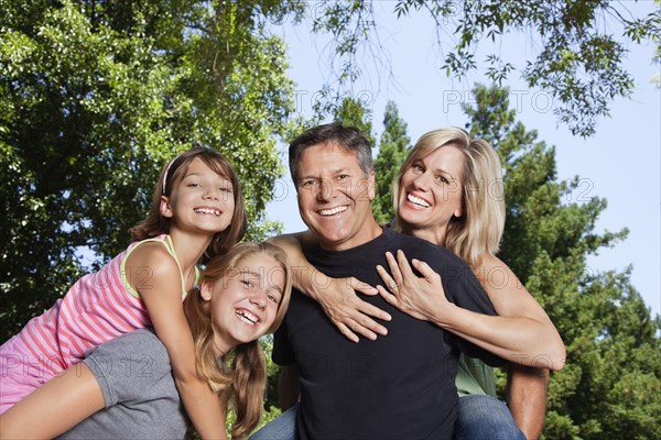 Caucasian family giving piggyback rides