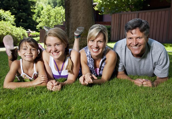 Caucasian family laying in grass