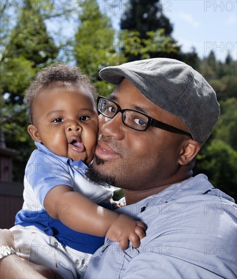 African American man cheek to cheek with baby son