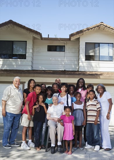 Large family standing in front of house