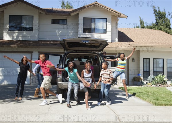 Family cheering in driveway of house