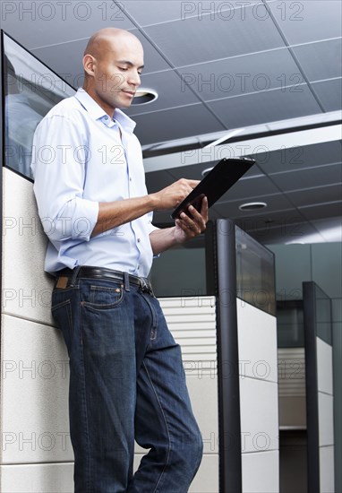 Mixed race businessman using digital tablet in office