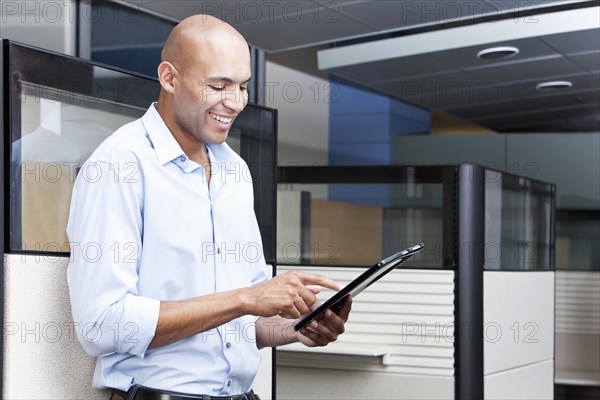 Mixed race businessman using digital tablet in office