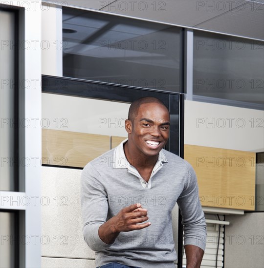 Smiling mixed race businessman standing in office