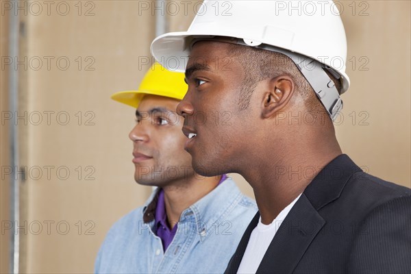 Mixed race businessmen in hard hats