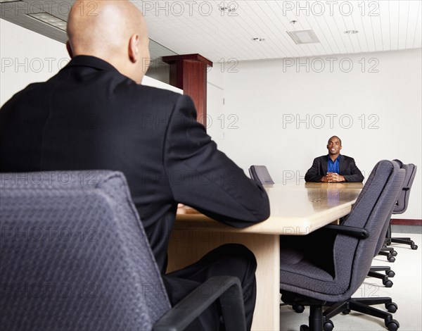 Mixed race businessmen having meeting in conference room