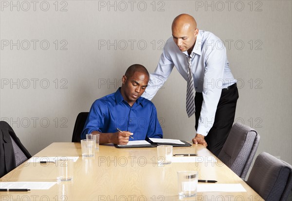 Mixed race businessmen working together in conference room