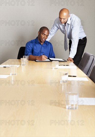 Mixed race businessmen working together in conference room