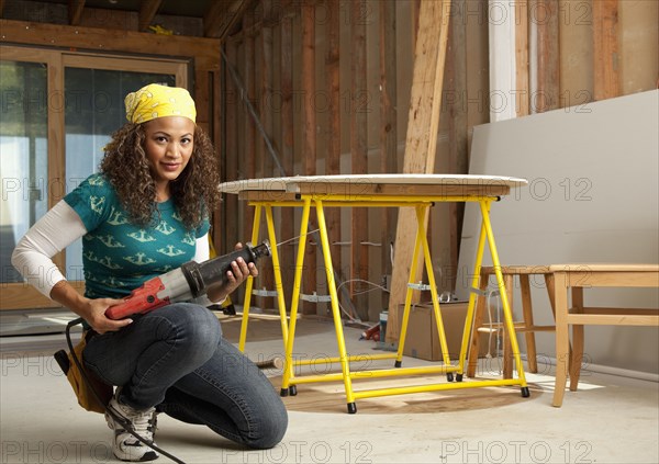 Hispanic woman holding power tool