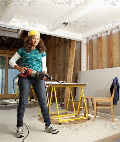 Hispanic woman holding power tool