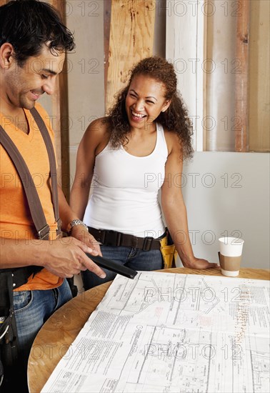 Hispanic couple looking at blueprints