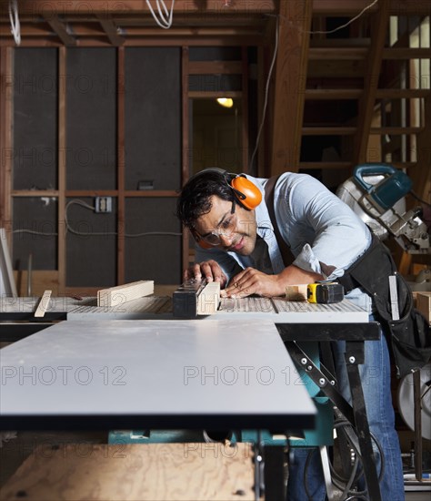 Hispanic worker using table saw