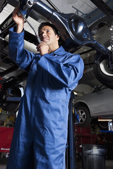 Middle Eastern mechanic working on car