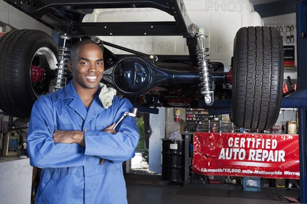 Black mechanic working on car