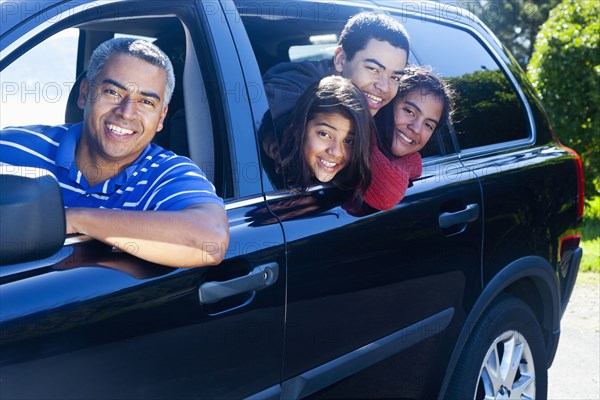 Hispanic family smiling in car