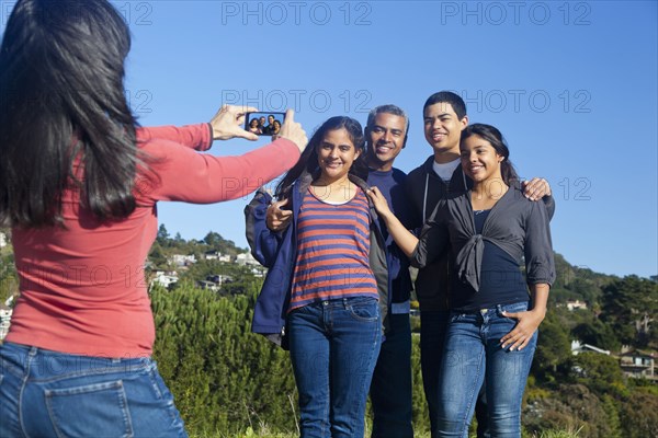 Hispanic family taking picture in park