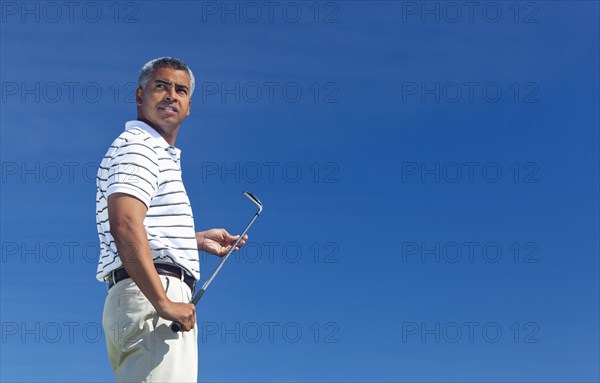 Mixed race man playing golf outdoors