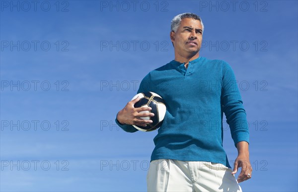 Mixed race man playing soccer outdoors