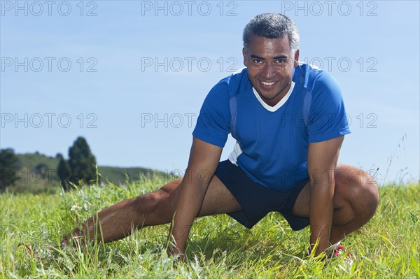 Mixed race man stretching outdoors