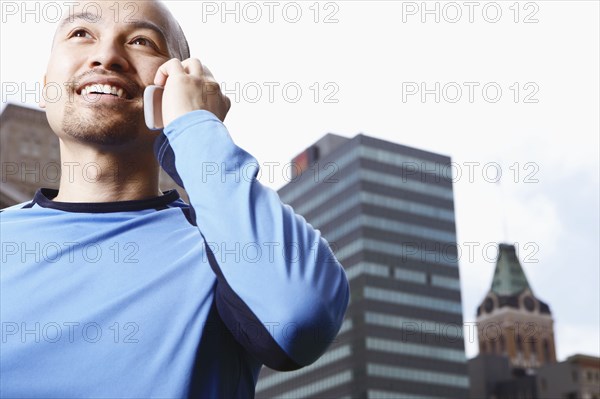 Chinese man talking on cell phone on city street