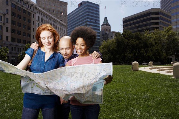 Friends reading map in urban park