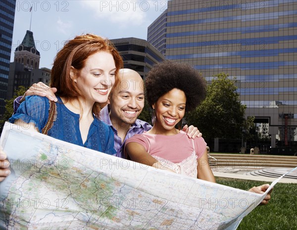 Friends reading map in urban park