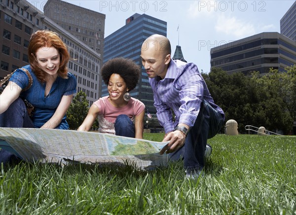 Friends reading map in urban park