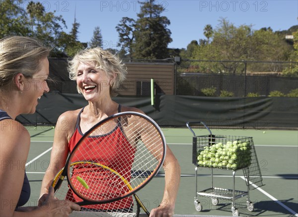 Caucasian women playing tennis on court