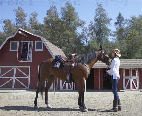 Mixed race girl petting horse on ranch
