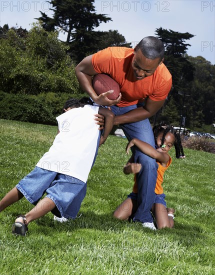 Father and children playing in park