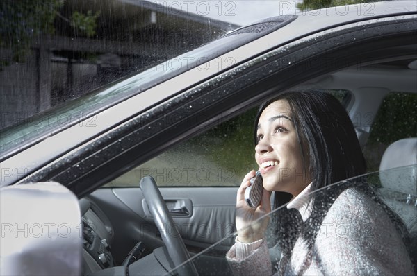 Indian woman watching rain from car