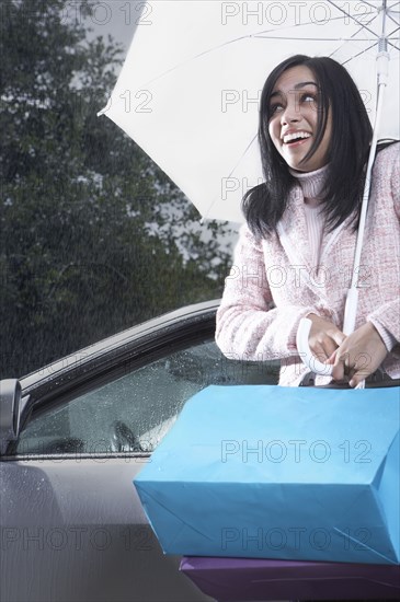 Indian woman carrying umbrella in rain