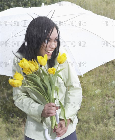 Indian woman carrying flowers in heavy rain