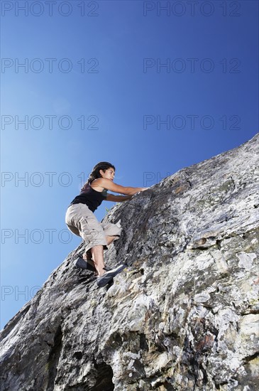 Hispanic climber scaling steep rock face