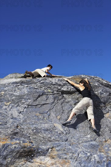 Climbers scaling steep rock face